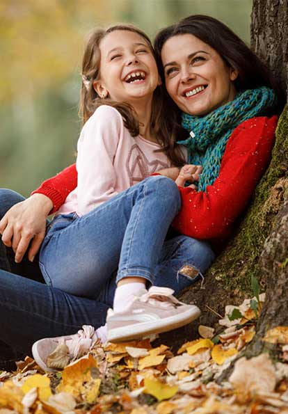 Mother and daughter hugging in a grassy field